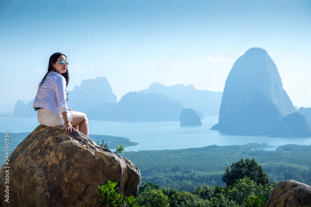 Fototapeta premium Young woman sitting on a mountain top