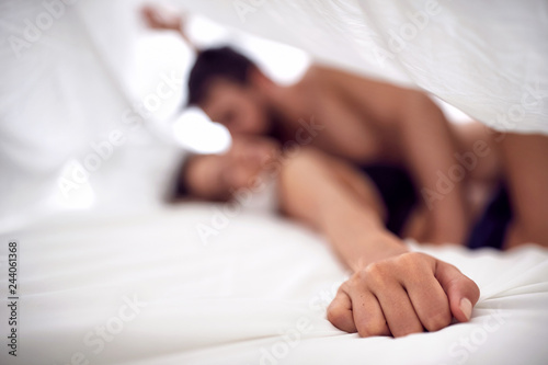 Hands of couple lovers having sex on a bed in morning. photo