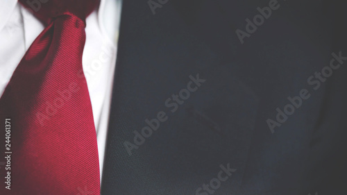 close up on black business suit and red tie 