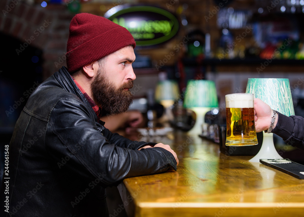 Man with beard spend leisure in dark bar. Brutal lonely hipster. Hipster relaxing at bar. Brutal hipster bearded man sit at bar counter. Friday evening. Bar is relaxing place to have drink and relax