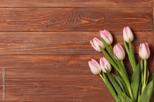 A bouquet of tulips on a wooden background top view. Spring background. Background to Mother's Day, International Women's Day, birthday.