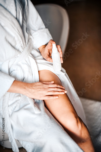Body care. A young woman in the bathroom applies natural cream to her legs. Against varicose veins and leg edema