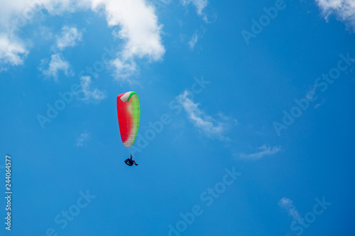 Skydiver On Colorful Parachute In Blue Sky. Active Hobbies