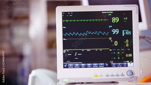 Ventilator monitor vital signs, EKG, ECG, Electrocardiographic selective focus against operating room, emergency room in the hospital, intensive therapy, treatment, critical or care unit, ICU ITU CCU