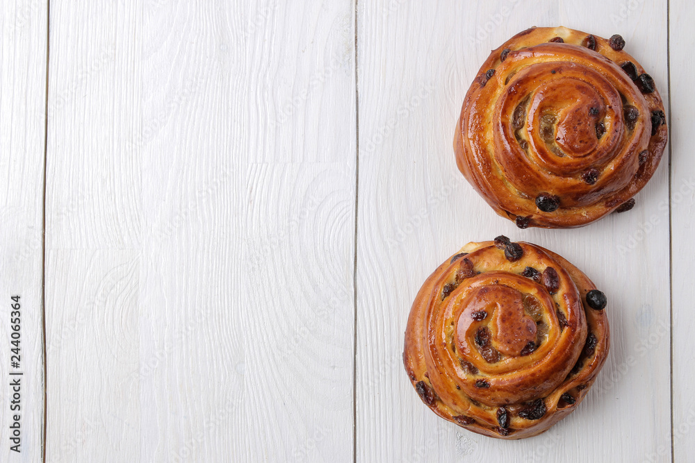 Tasty buns with raisins on white wooden background. fresh bakery. breakfast. top view with space for text Tasty buns with raisins on white wooden background. fresh bakery. breakfast. top view with space for text
