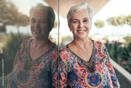 Portrait of a beautiful grey haired middel aged woman smiling and looking out into the camera photo