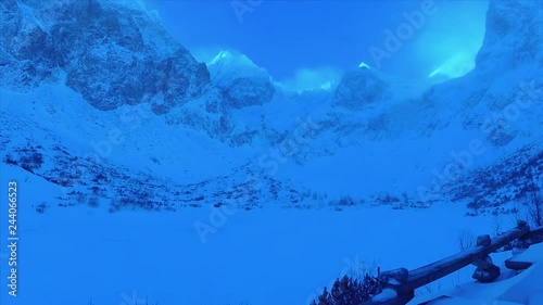 Wooden Tables Near the Frozen Lake in Tatras Mountains Slovakia, Mountain Hut in Slovakia, Snow Peaks In High Tatras Mountains photo