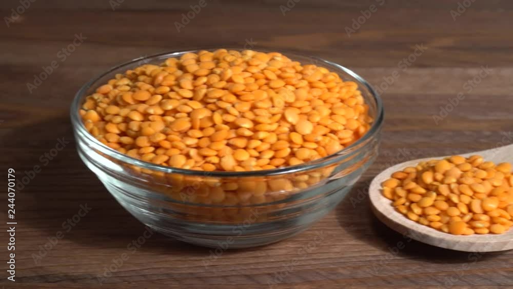 Lentejas naranjas crudas en un bol en la mesa de madera Lentejas naranjas crudas en un bol en la mesa de madera