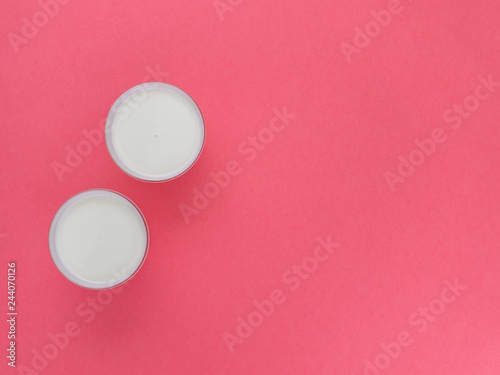 Healthy breakfast. Yogurt in white glasses on pink background. Copy space, flat lay, top view
