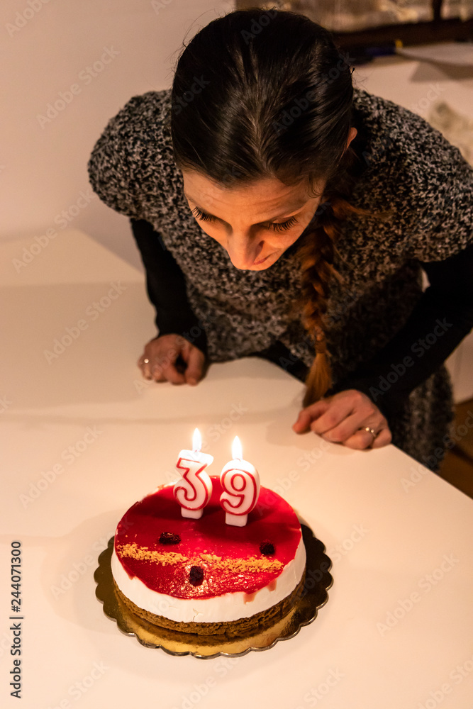 a young woman extinguishes the candles for her 39th birthday. A girl reaches the age of maturity. a young woman extinguishes the candles for her 39th birthday. A girl reaches the age of maturity.