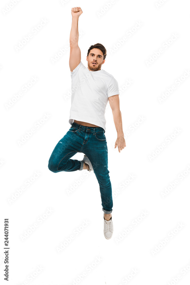 serious handsome man jumping with raised hand and looking at camera isolated on white serious handsome man jumping with raised hand and looking at camera isolated on white