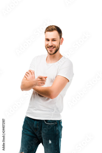 handsome happy man pointing with finger and smiling at camera isolated on white