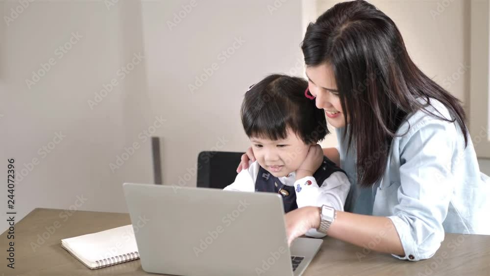 Asian Mother and daughter 5 years old using laptop computer together at home. Education and Technology concept Slow Motion Asian Mother and daughter 5 years old using laptop computer together at home. Education and Technology concept Slow Motion
