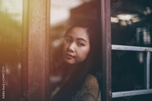 Asian woman at the window watching