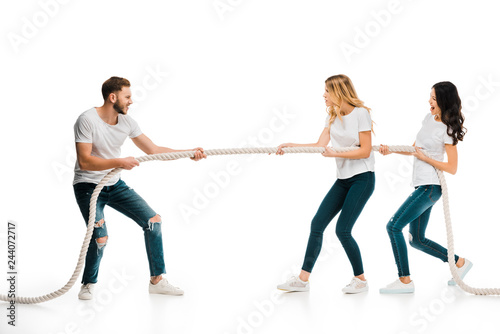 Obraz na plátně emotional young man and women pulling rope isolated on white