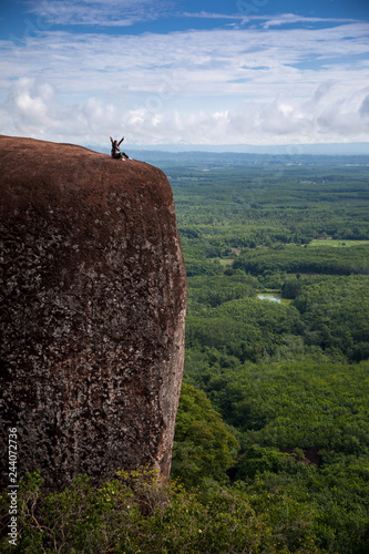 Young woman sitting on a mountain top photo