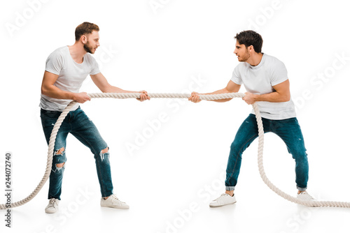 young men pulling rope and playing tug of war isolated on white photo