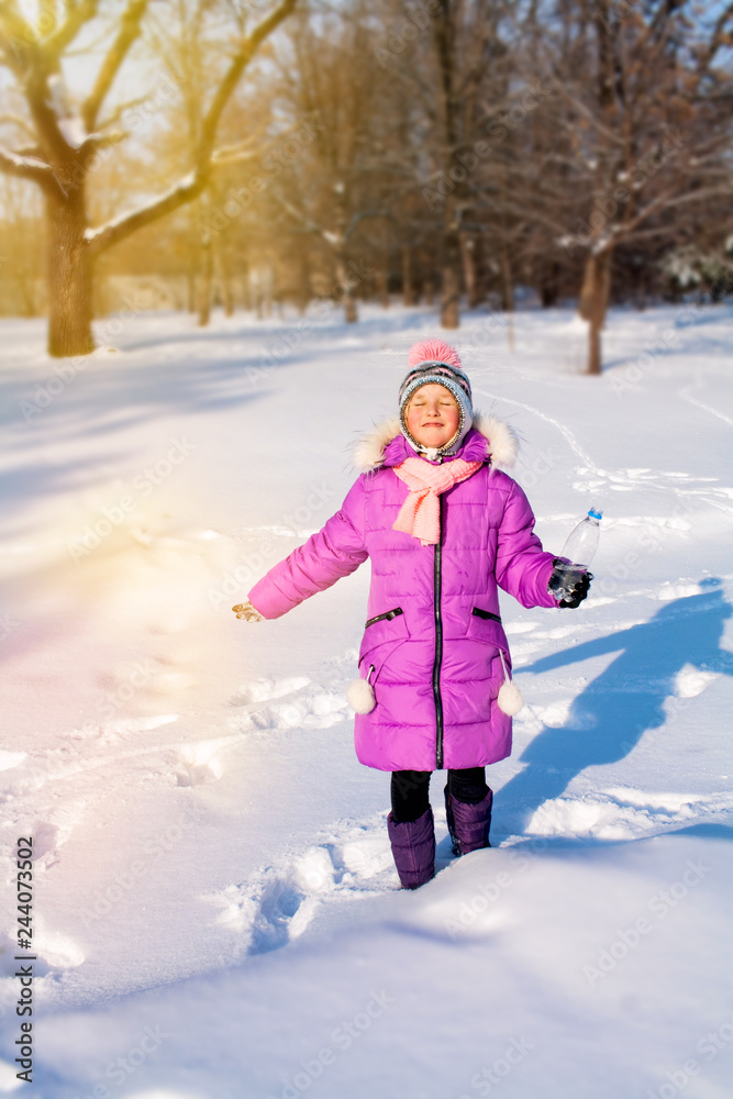 Open portrait the Happy child, in the winter park . the child drinks water in the open air . winter sunny day . Winter activity concept . I want to drink . natural drink . Open portrait the Happy child, in the winter park . the child drinks water in the open air . winter sunny day . Winter activity concept . I want to drink . natural drink .