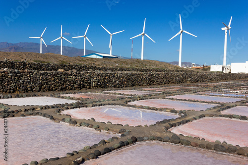 Pink salt mines with wind turbines factory on background in Pozo Izquierdo, Gran Canaria. Cultural park in natural environment with unique ecosystem on sunny day in Canary Islands, Spain photo