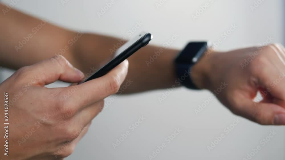 Sport, fitness, technology, and people concept - close up of male hand holding smart phone and wearing smartwatch, 4K, Prores, 60 fps Sport, fitness, technology, and people concept - close up of male hand holding smart phone and wearing smartwatch, 4K, Prores, 60 fps
