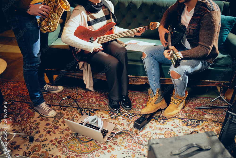 Fototapeta premium Musicians having rehearsal in home studio. On the floor amplifiers, laptop and headphones.