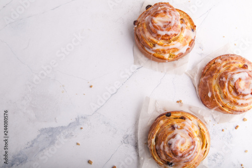 Cinnamon rolls buns on a white marble background. Bakery concept. Breakfast and brunch. Flatlay. Overhead. Copy space
