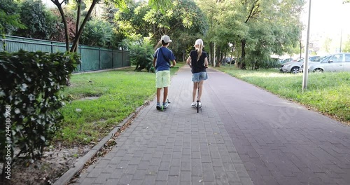 Wallpaper Mural Two children ride scooters outdoors. Torontodigital.ca