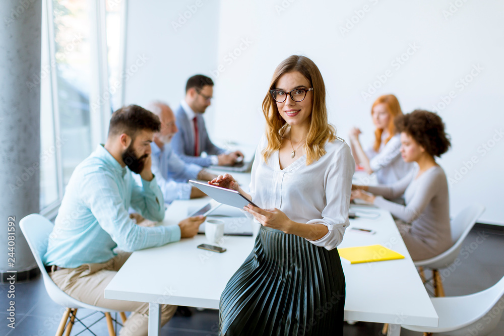 Elegant businesswoman standing in office with digital tablet