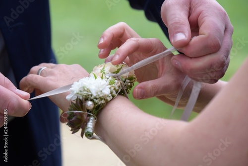 Blumenarmschmuck zur Hochzeit, gebunden mit einer Schleife am Handgelenk