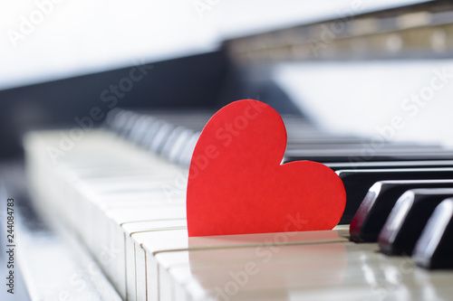 Red bright heart on a keyboard of an old piano. Cocept of love, valentine's day photo