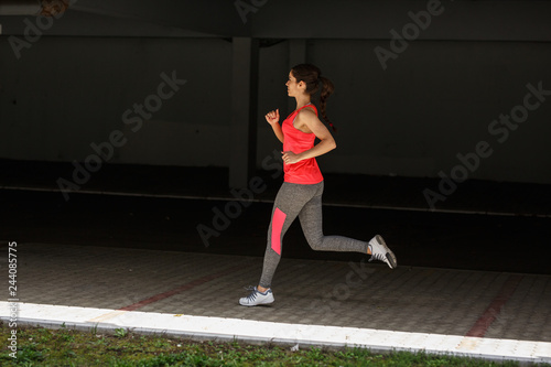 Female runner jogging trough parking lot.Fitness and jogging concept.