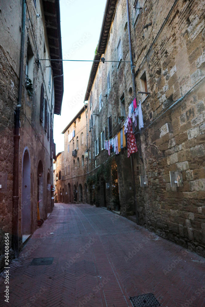 Street in medieval town San Gimignano with drying clothes on the rope, Tuscany, Italy