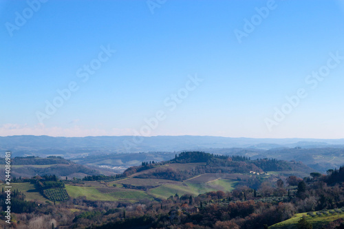 Winter morning Tuscany landscape with trees and blue sky, San Gimignano, Italy