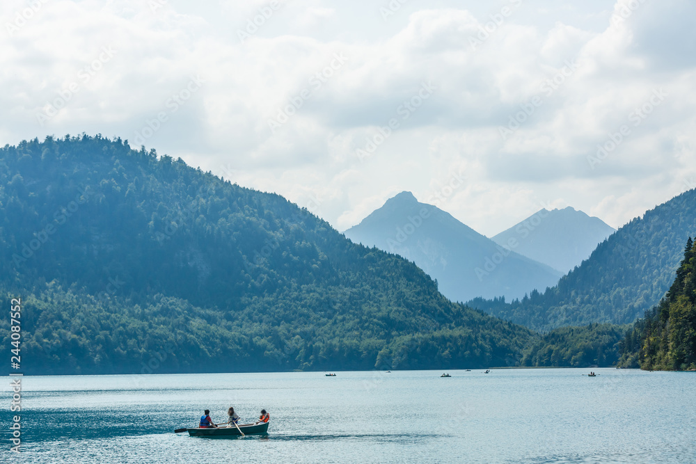 Rest on a mountain lake near Neuschwanstein. family is sitting in the boat