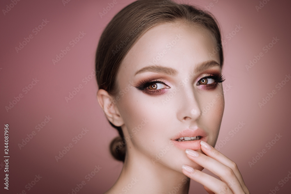 portrait of a beautiful elegant brunette girl with makeup and haircut in the studio on a pink background portrait of a beautiful elegant brunette girl with makeup and haircut in the studio on a pink background