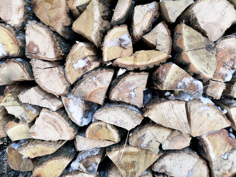 Firewood in winter. The texture of impaled wood in the snow