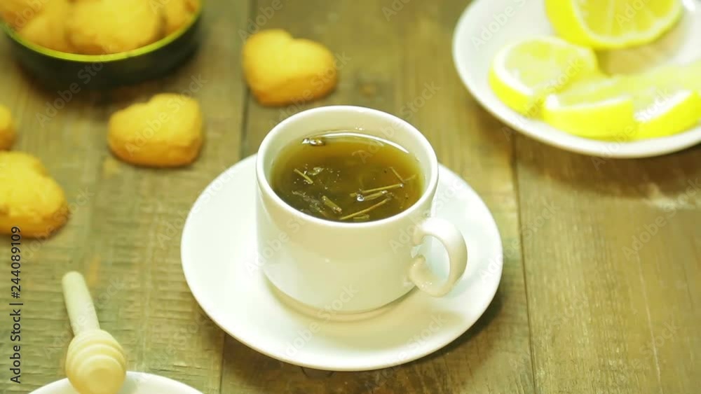 A cup of freshly brewed green tea on a wooden table. A cup of freshly brewed green tea on a wooden table.