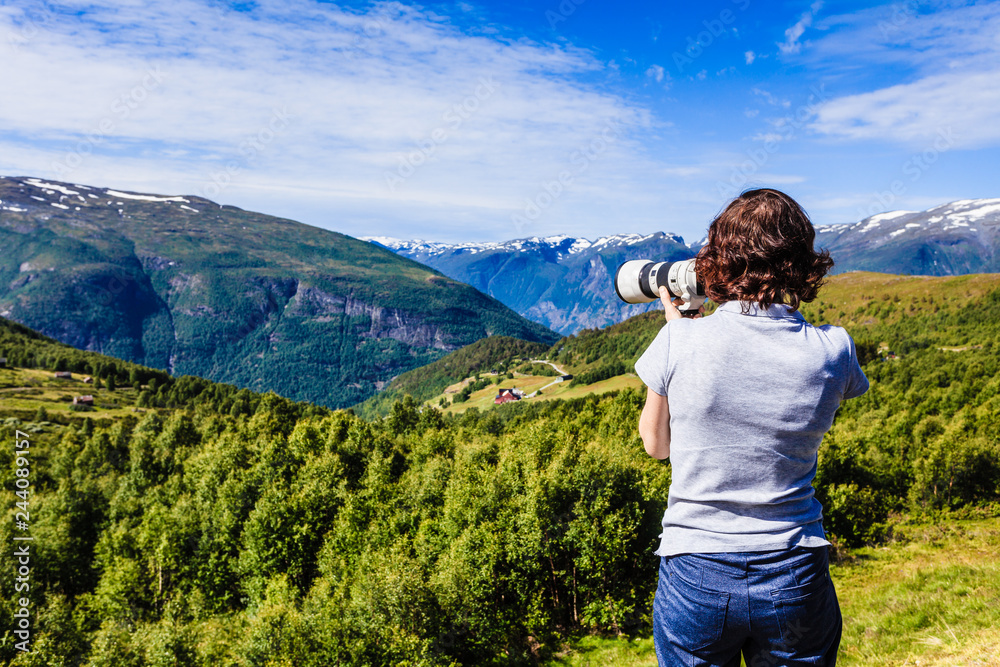 Naklejka premium Tourist taking photo in norwegian nature