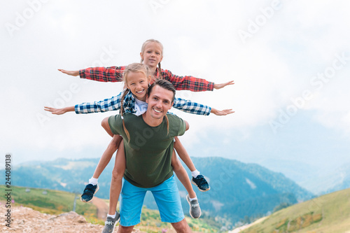 Beautiful kids and happy man in mountains in the background of fog