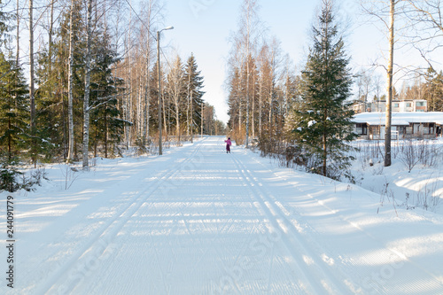 Small child in the ski track at winter forest in Finland.