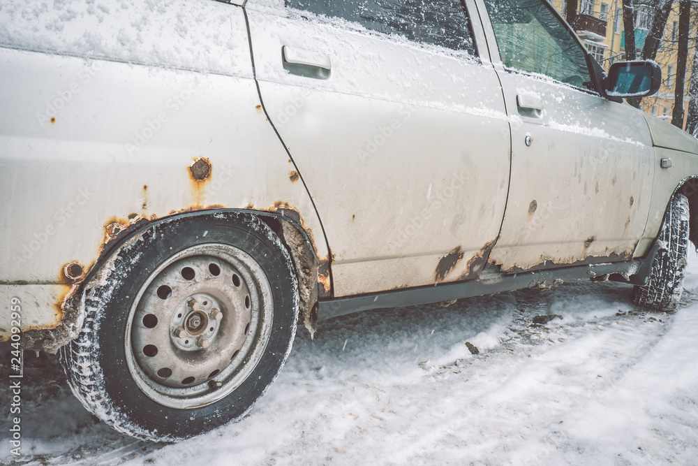 The bottom of the doors and the bottom of the white car in winter is covered with a caustic iron defect. The bottom of the doors and the bottom of the white car in winter is covered with a caustic iron defect.
