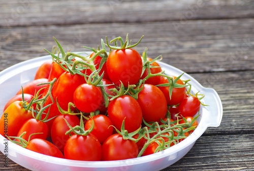 Fresh red cherry tomato from organic garden on a old wooden background for healthy.