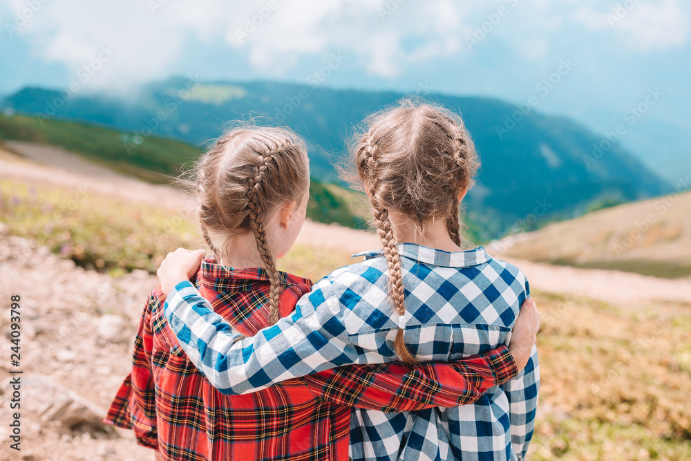 Beautiful happy little girls in mountains in the background of fog Beautiful happy little girls in mountains in the background of fog