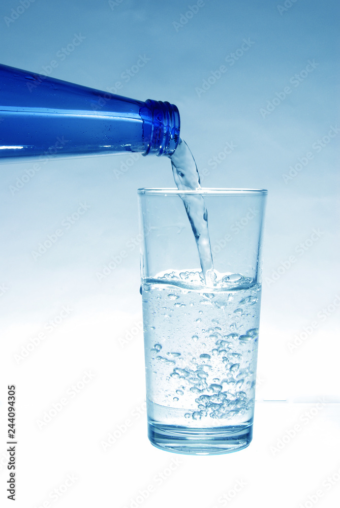 Mineral water pours from the bottle into the glass Mineral water pours from the bottle into the glass