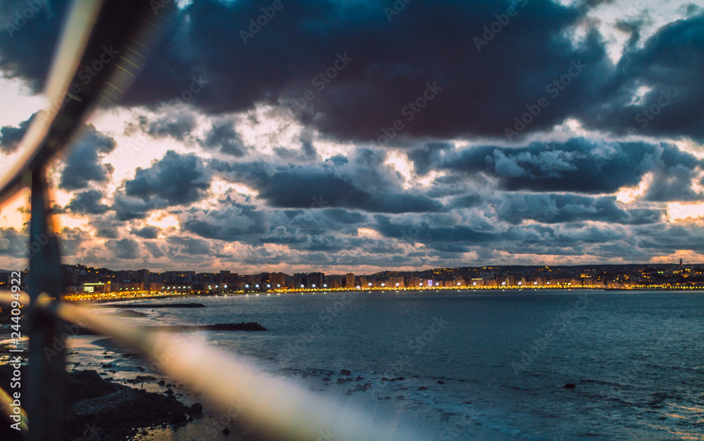 Downtown city skyline under beautiful cloud formation at night. Tangier, Morocco