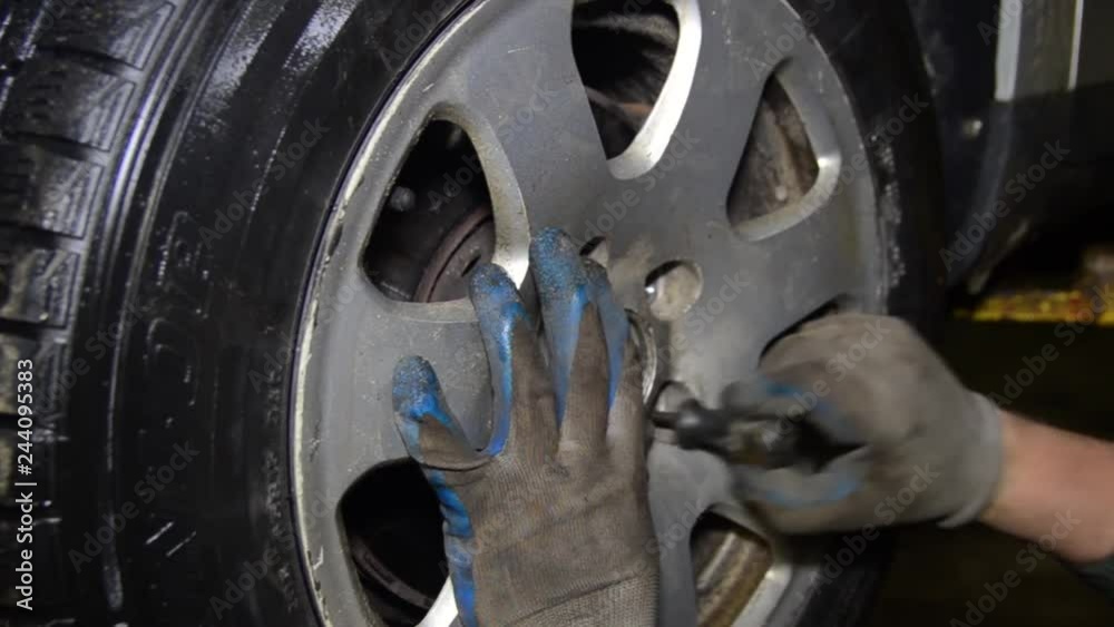 Closeup view of a mechanic spinning a car wheel Closeup view of a mechanic spinning a car wheel