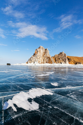Lake Baikal in winter. The famous Cape Burkhan near the village of Khuzhir and the Shamanka rock is a natural landmark. Tourists travel on the ice by car