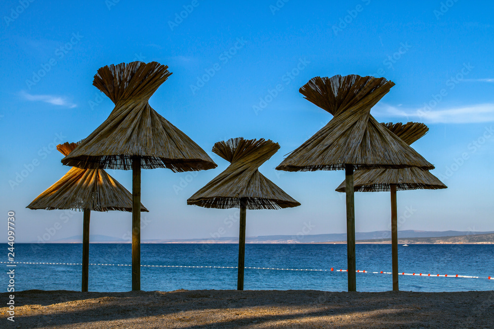 Nice view of beach Croatia. Crystal clear waters and beach umbrellas .  Croatia vacation. Europe. European travel.