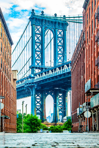 Manhattan Bridge between Manhattan and Brooklyn over East River seen from a narrow alley enclosed by two brick buildings on a sunny day in Washington street in Dumbo, Brooklyn, NYC photo