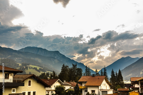 Idyllic landscape in the Alps with fresh green meadows, blooming flowers, typical farmhouses and snowcapped mountain tops in the background, Bavaria, Germany